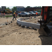 A worker walking past the drying concrete retaining wall