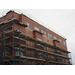 Construction outside the building continues, scaffolding reaching up to the 3rd story