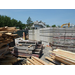 Wood and other building materials stacked next to the foundation walls